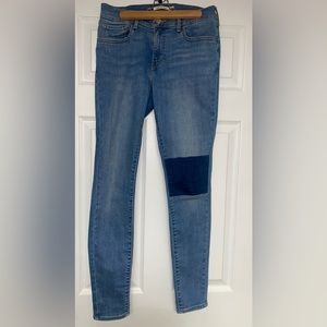 710 super skinny Levi’s jeans medium wash with a dark wash patch on one knee